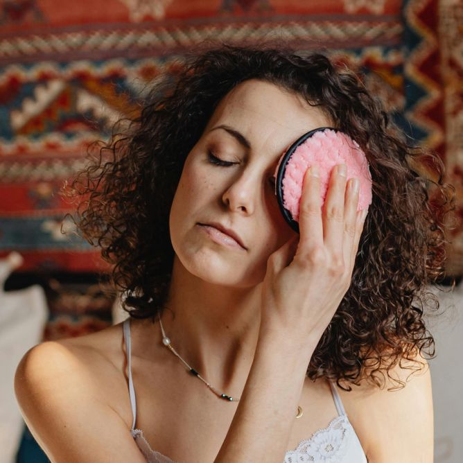 Femme se faisant des compresses chaudes ou froides pour calmer ses spasmes de paumières