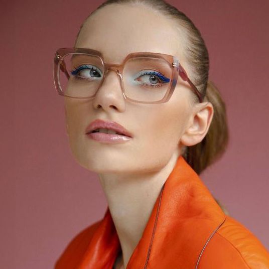 Jeune femme, cheveux tirés et sophistiquée, portant des grandes lunettes oversize translucides rose